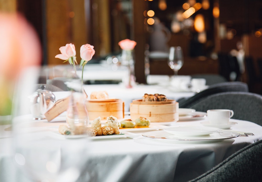 Above &amp; Beyond Hong Kong restaurant table setting with flowers and dim sum basket